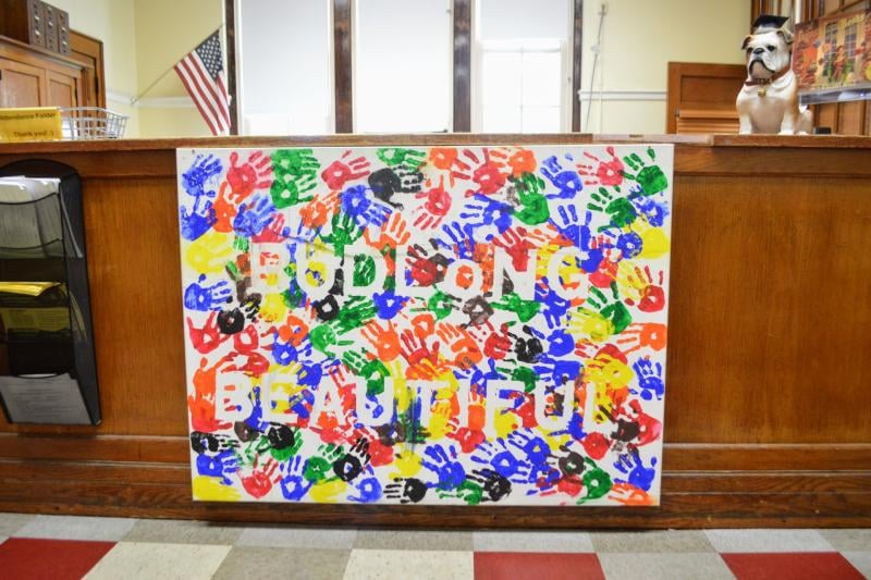 a sign with colorful handprints on it