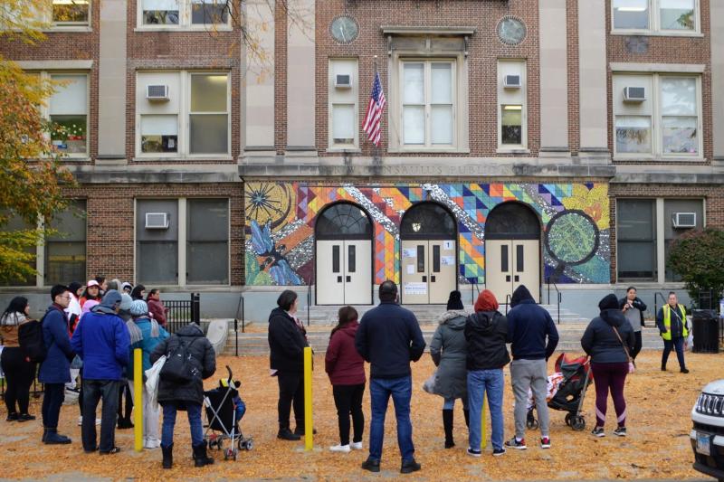 People outside a school building in autumn