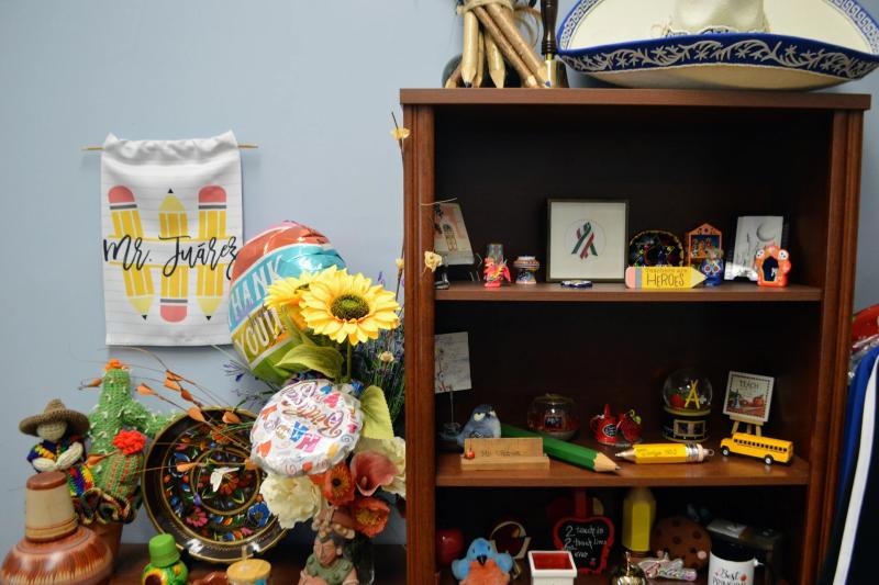 a shelf with various objects and flowers