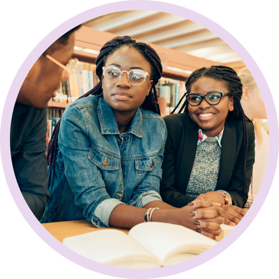 Two smiling students in a library