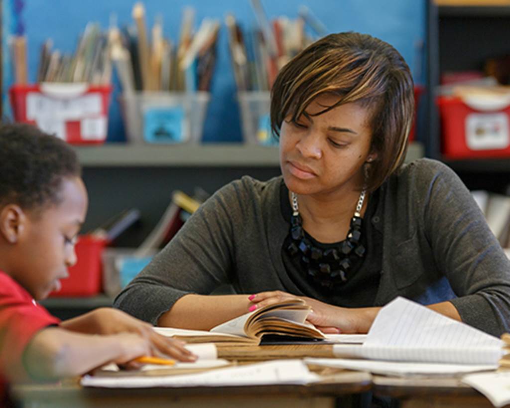 A parent helps a child learn in class