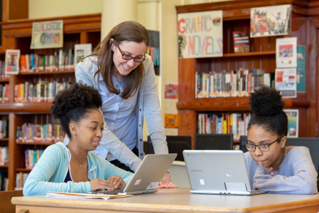 Teacher and student looking at a laptop