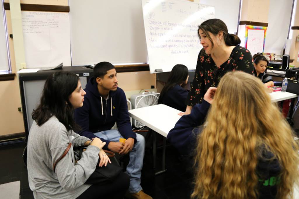 Students converse with teacher