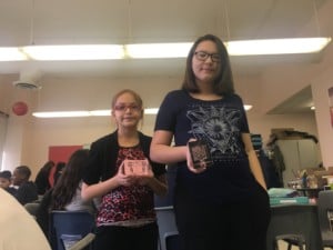 Students, Naomi, left, and Isabella, right, use rubber blocks to carve out images to print.