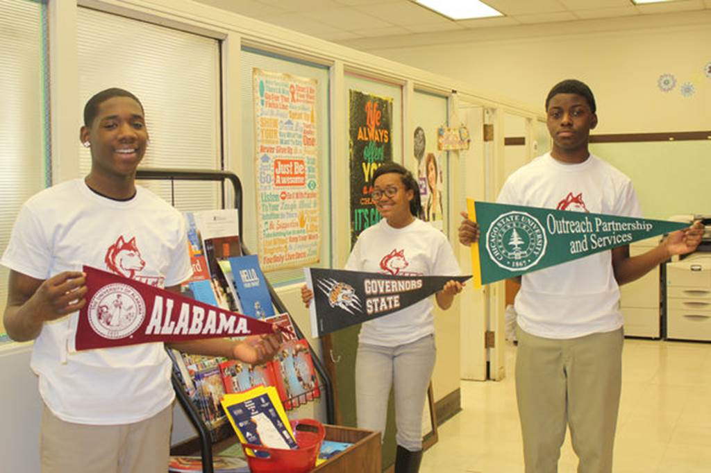 The students hold college flags