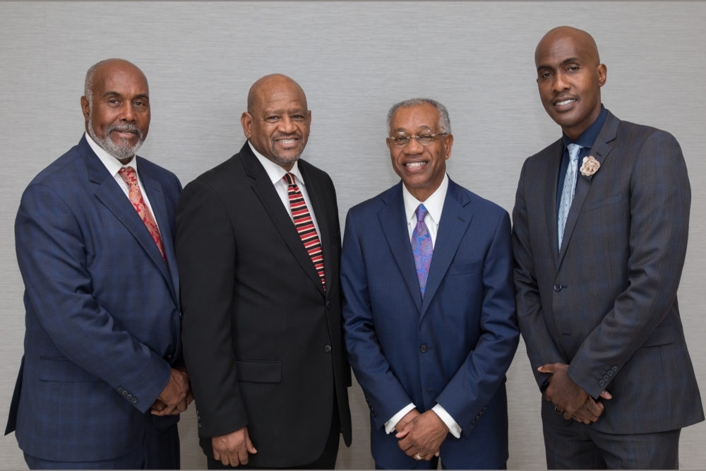 Four African American men stand together