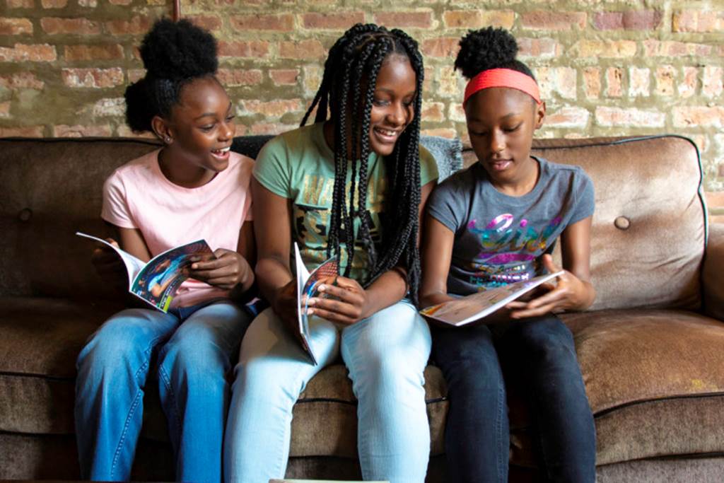 Three sisters hold books