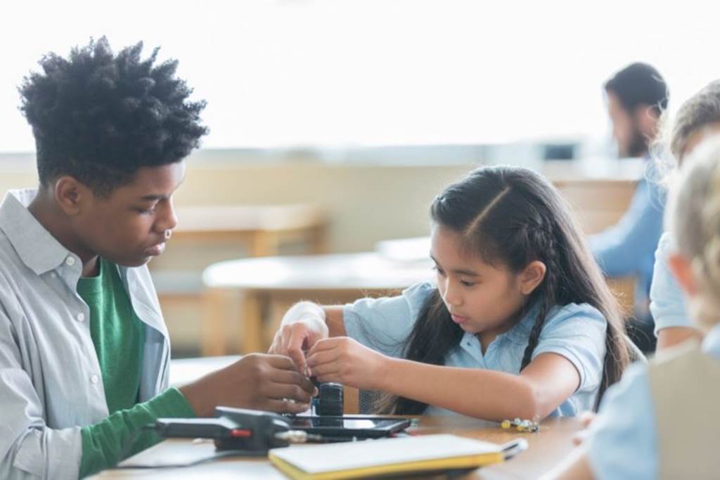 An older student making crafts with a younger student