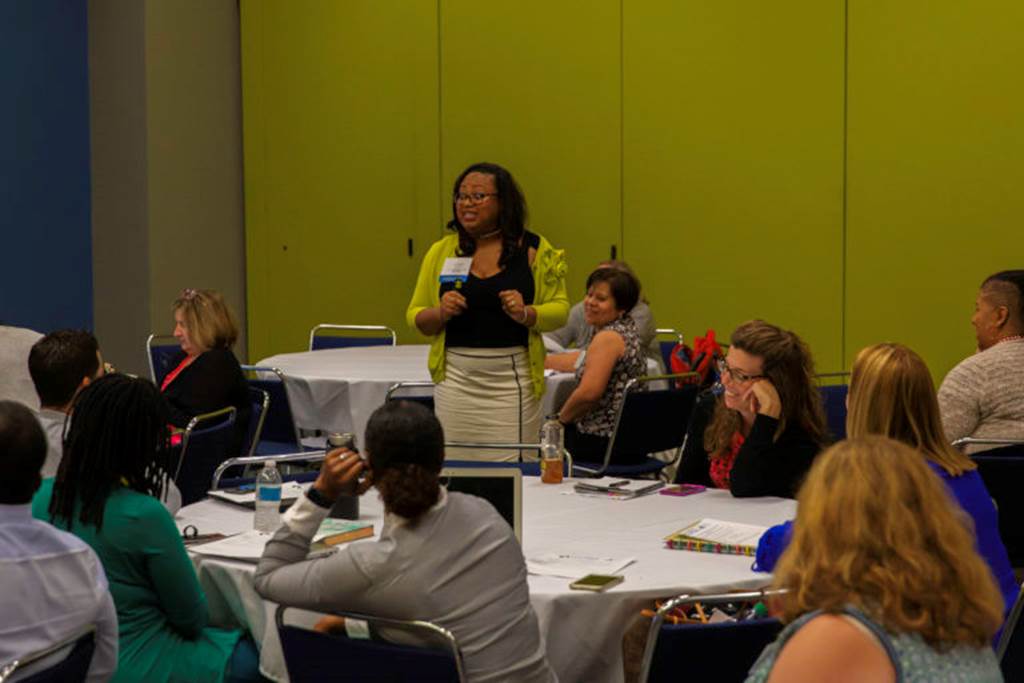 A woman with a microphone talks to her audience