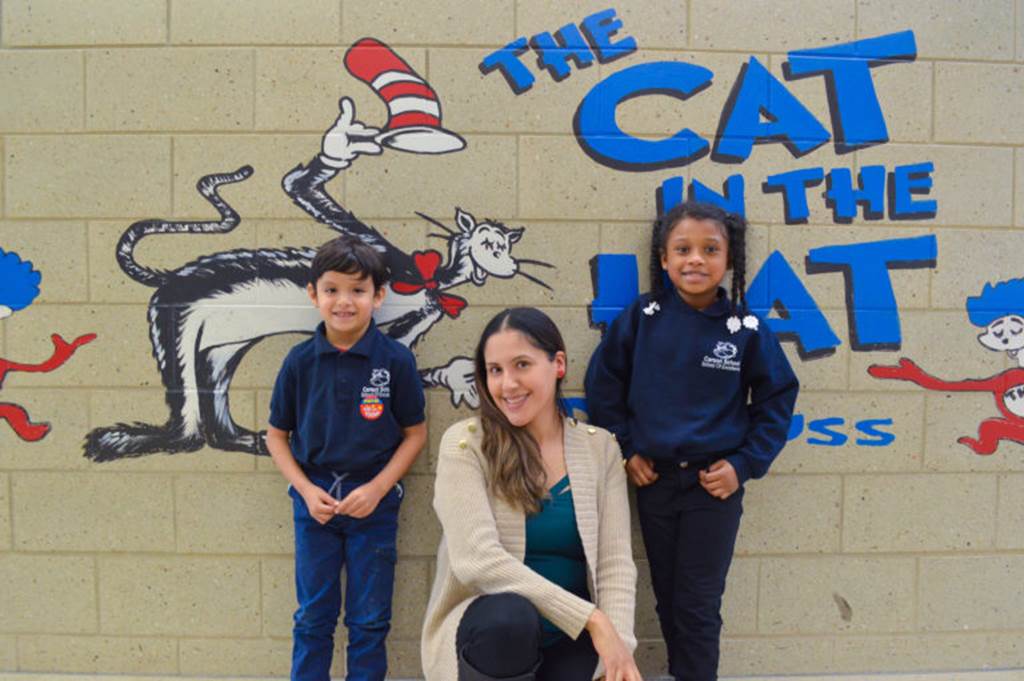 Two students and a teacher pose