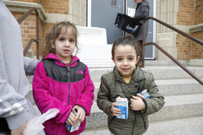 Two girls holding milk cartons