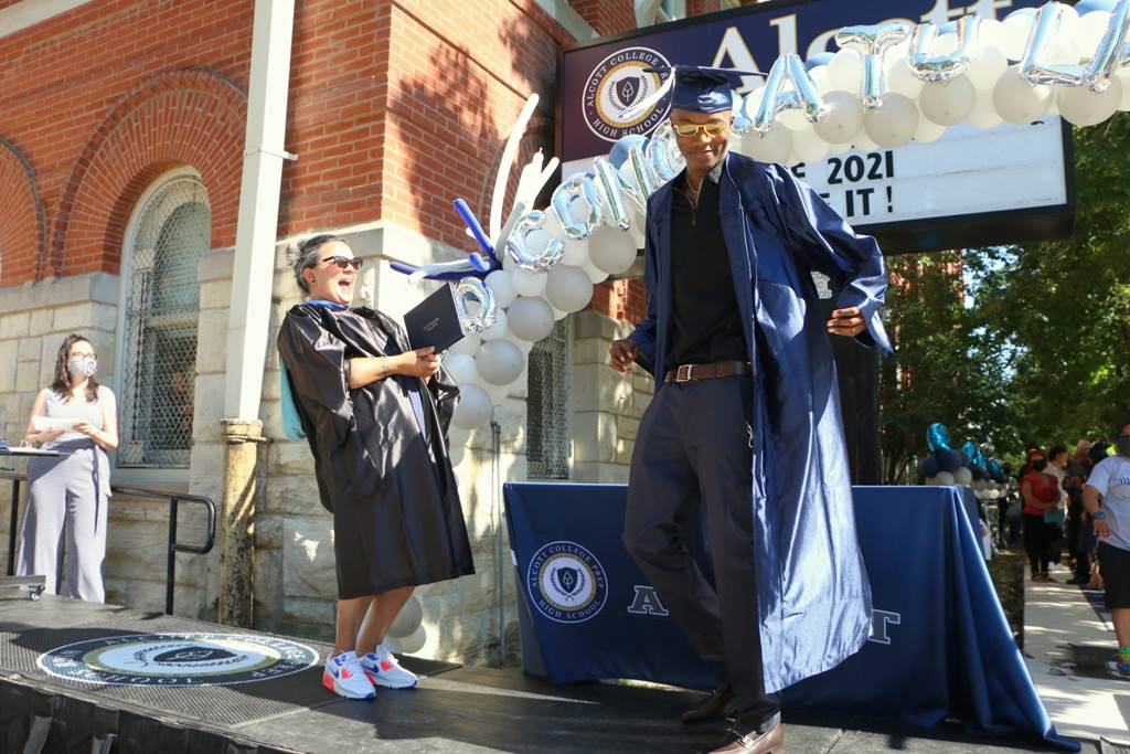 A graduate on stage accepting his diploma