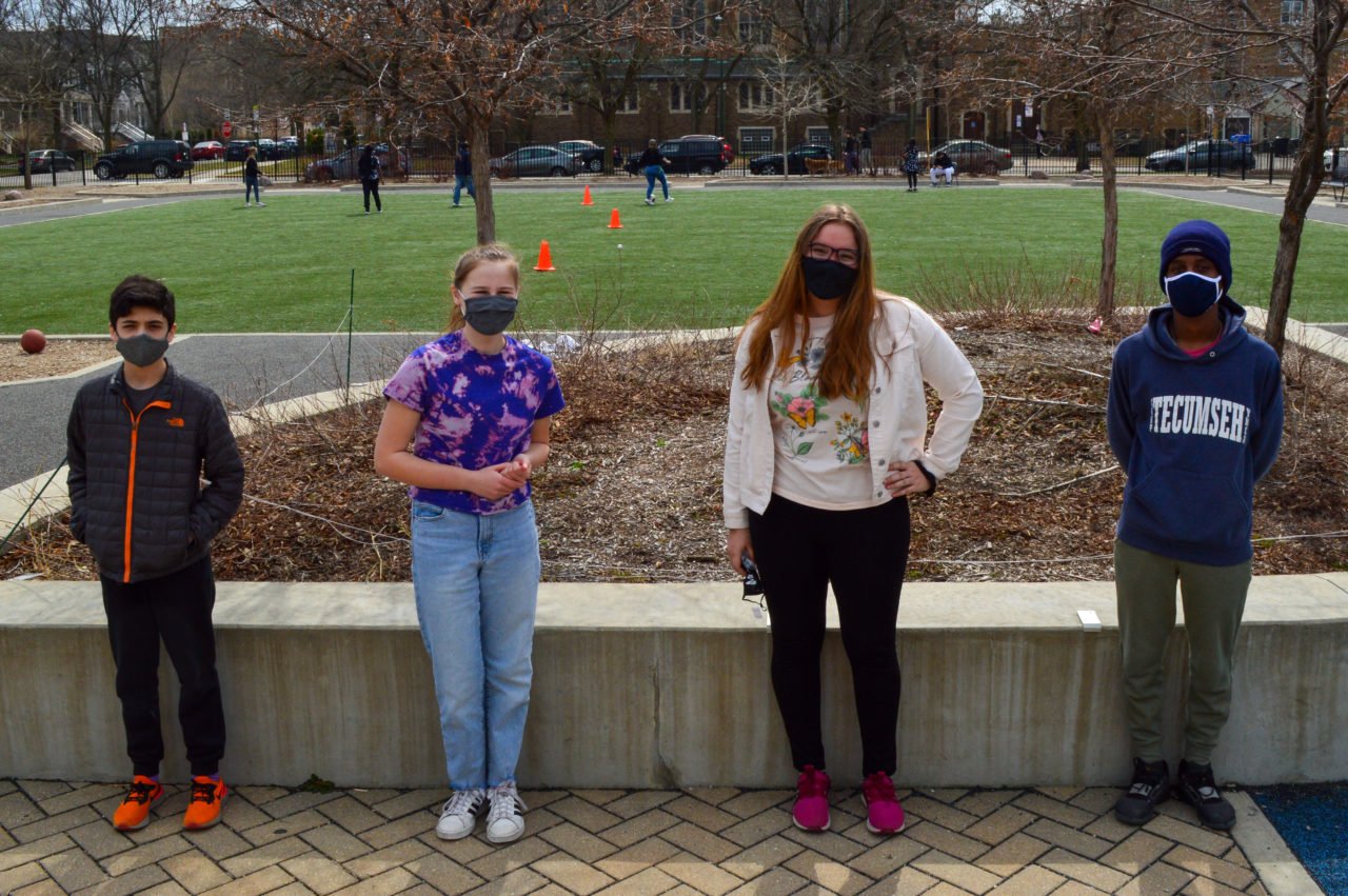 Four students standing up