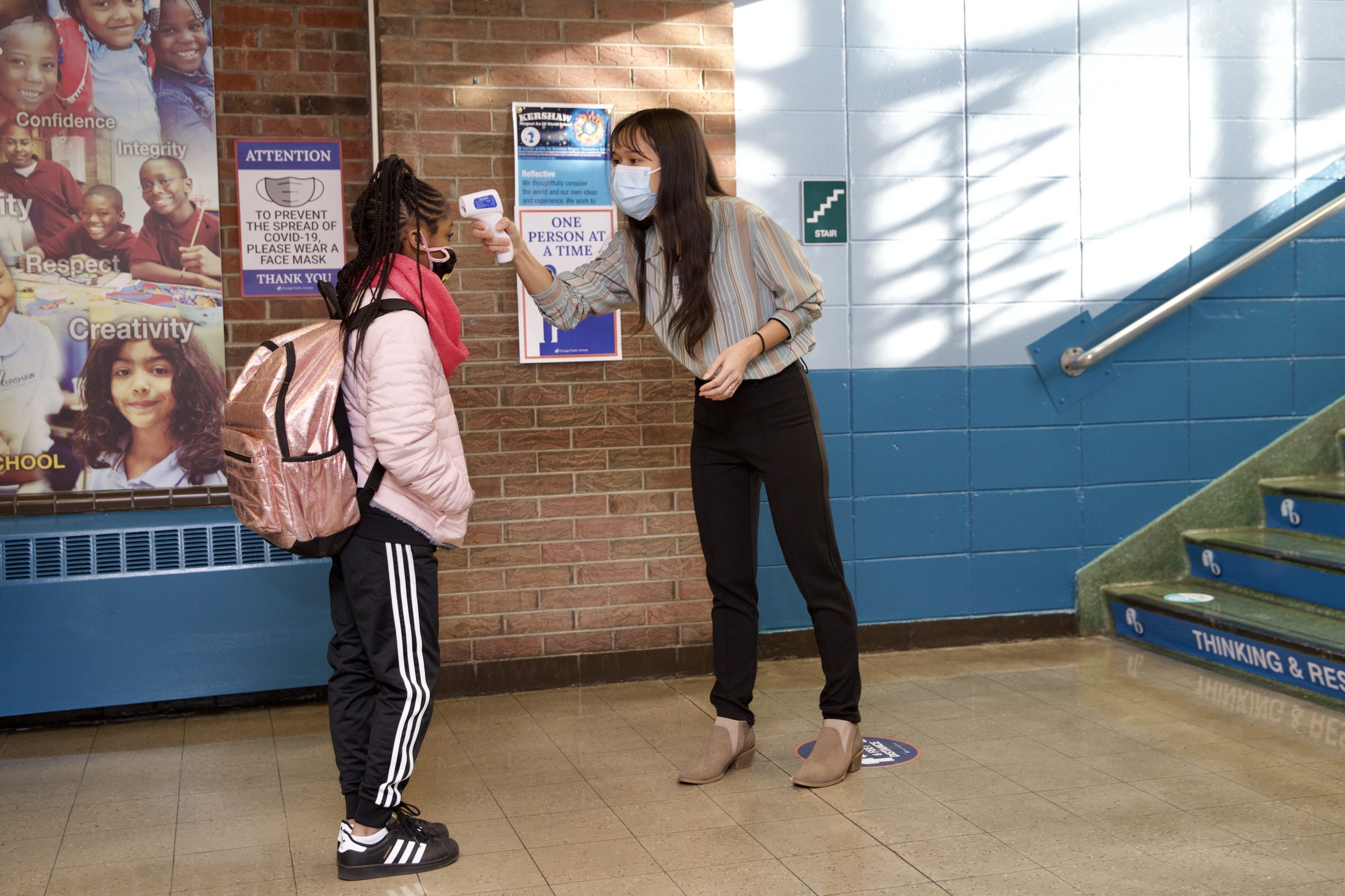 student getting her temperature taken