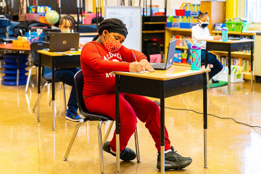 A student writing at her desk