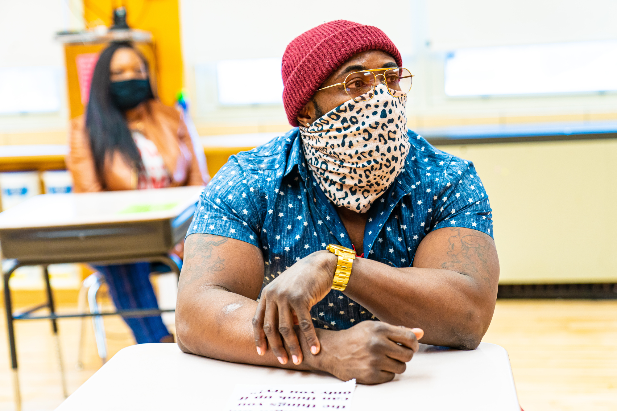 A man in sun glasses sitting at a desk