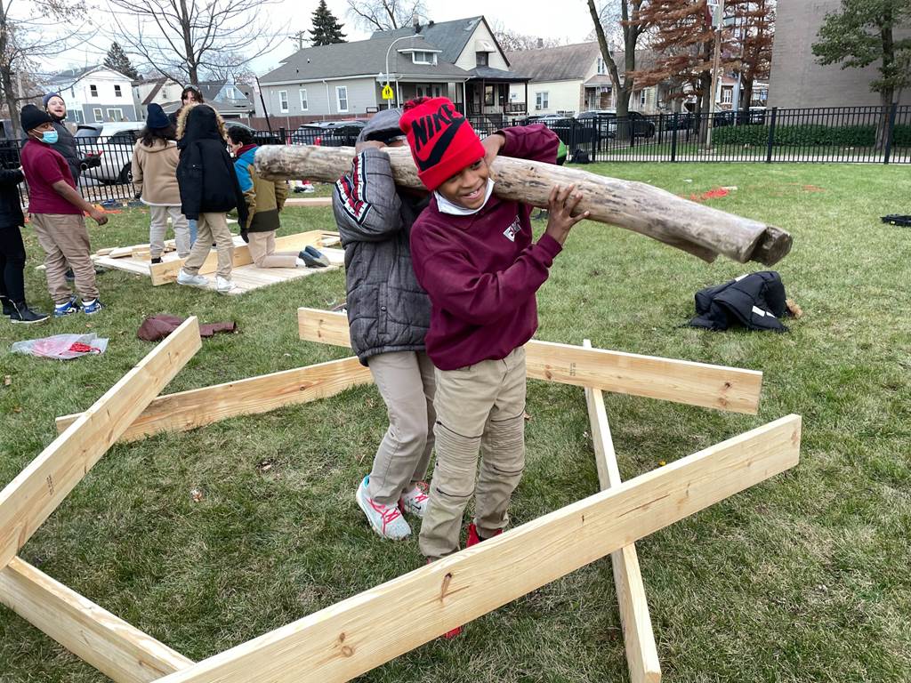 Students moving wooden planks