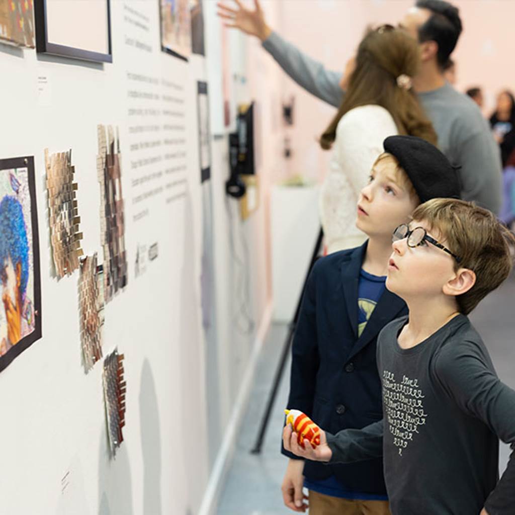 Two young children admiring student artwork